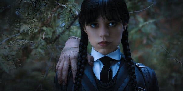 Wednesday Addams with Thing on Netflix's Wednesday.